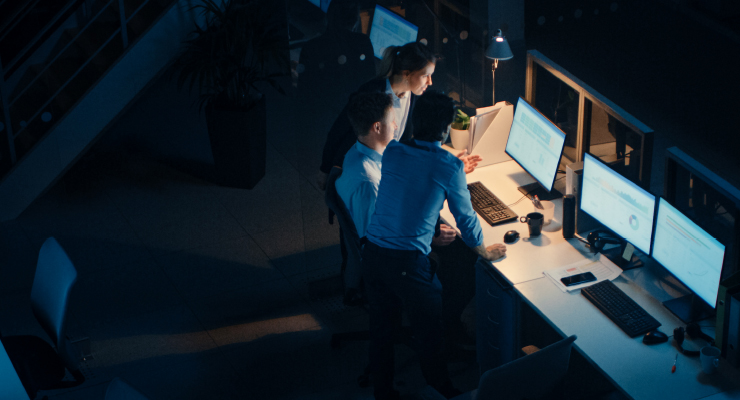 Image of multiple people working at a computer