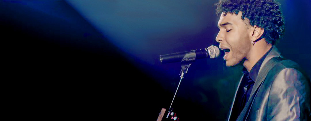 Image of a man singing on stage