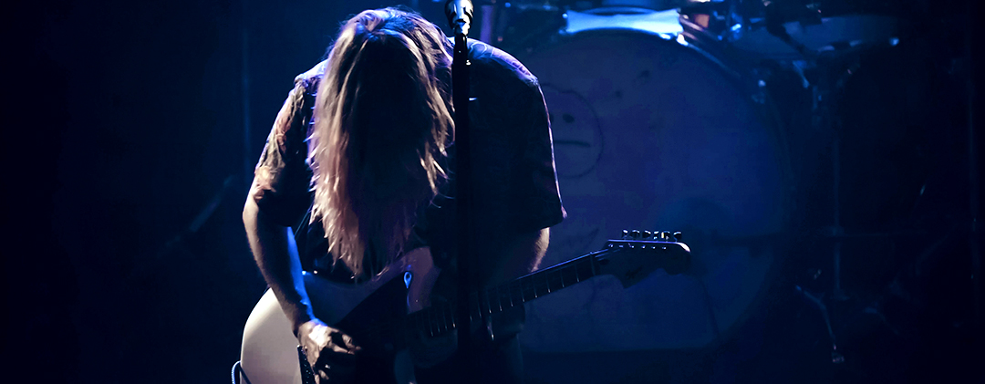 Image of a person playing guitar on stage