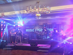 Band performing on stage at the Rock School Seminar and Concert in China, powered by the QSC TouchMix