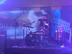 Band performing on stage at the Rock School Seminar and Concert in China, powered by the QSC TouchMix